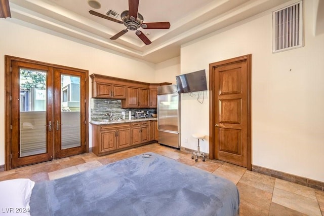 kitchen with decorative backsplash, french doors, a tray ceiling, ceiling fan, and built in fridge