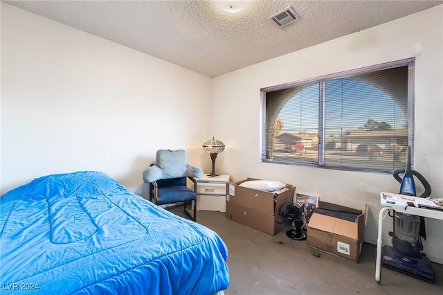 bedroom featuring a textured ceiling and concrete floors