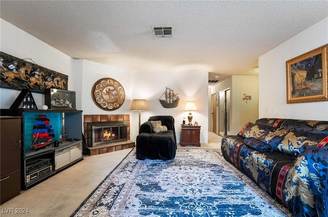 carpeted living room featuring a tiled fireplace and a textured ceiling