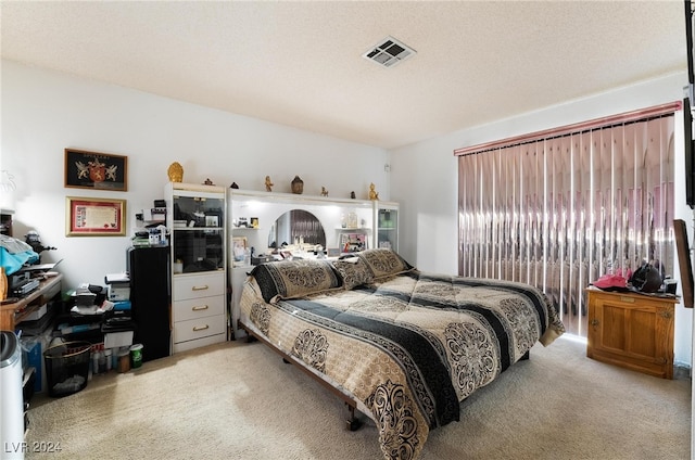 carpeted bedroom featuring a textured ceiling