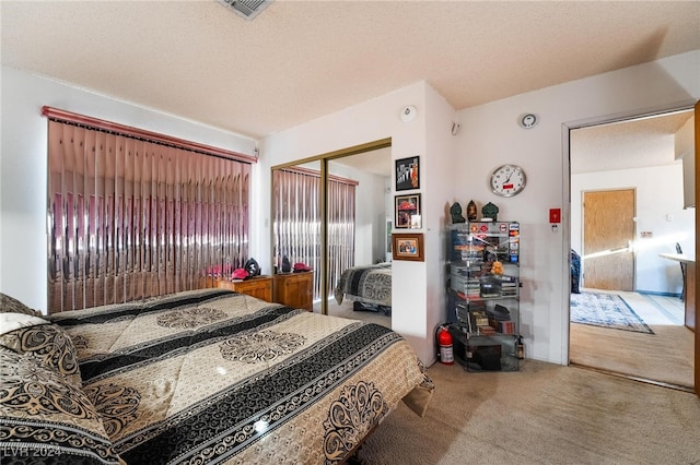 carpeted bedroom with a closet and a textured ceiling