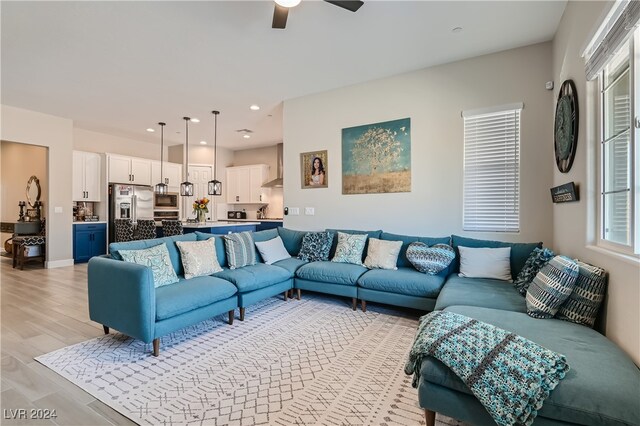 living room featuring ceiling fan and light hardwood / wood-style flooring