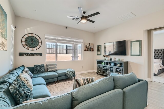 living room with light wood-type flooring and ceiling fan