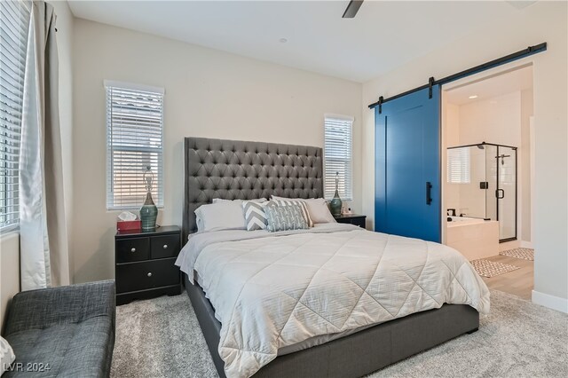 bedroom featuring ensuite bath, multiple windows, carpet floors, and a barn door