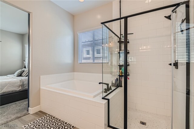 bathroom with independent shower and bath and hardwood / wood-style flooring