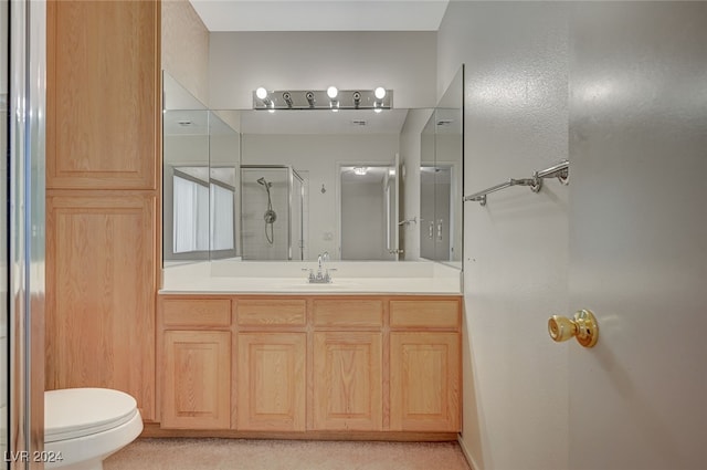 bathroom with an enclosed shower, vanity, and toilet