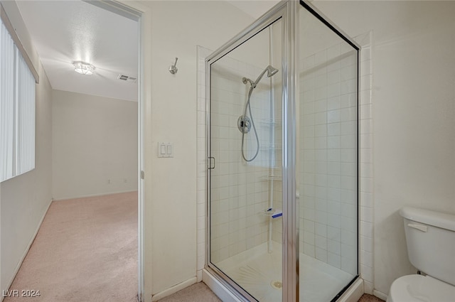 bathroom with toilet and an enclosed shower