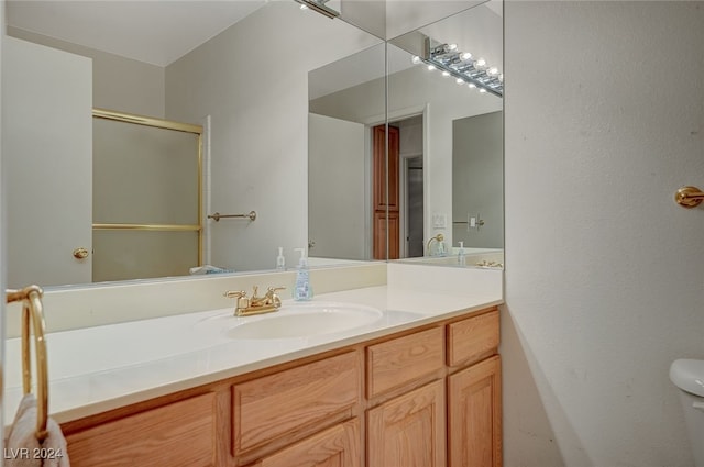 bathroom with walk in shower, vanity, and toilet