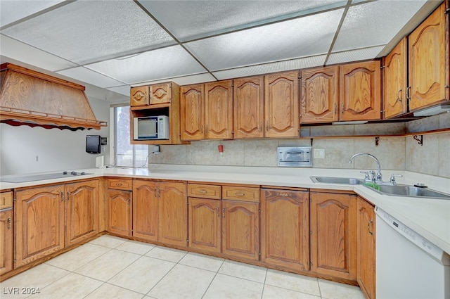 kitchen with light tile patterned flooring, sink, white appliances, a paneled ceiling, and decorative backsplash