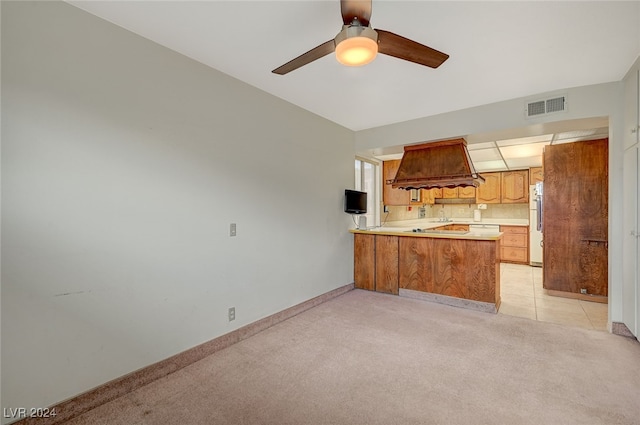 kitchen featuring white fridge, light carpet, kitchen peninsula, and ceiling fan