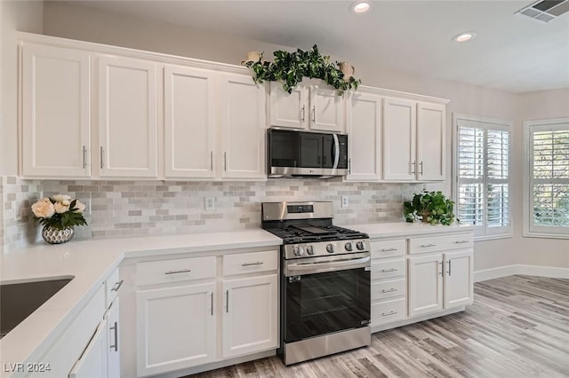 10315 Premia Pl, Las Vegas, NV 89135 - kitchen featuring stainless steel appliances, white cabinetry, backsplash, light countertops, and recessed lighting