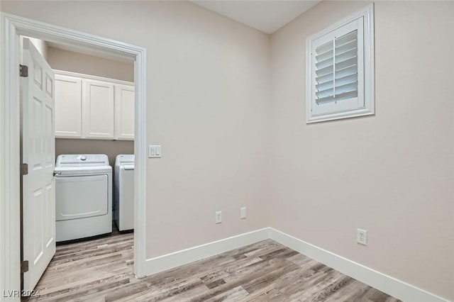 laundry area with cabinets, washer and dryer, and light hardwood / wood-style floors