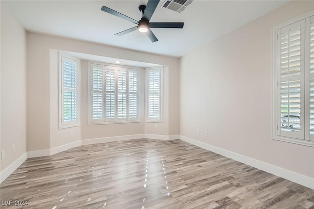 spare room featuring ceiling fan, plenty of natural light, and light hardwood / wood-style flooring