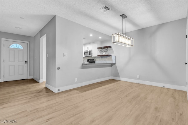 interior space with light hardwood / wood-style floors and a textured ceiling