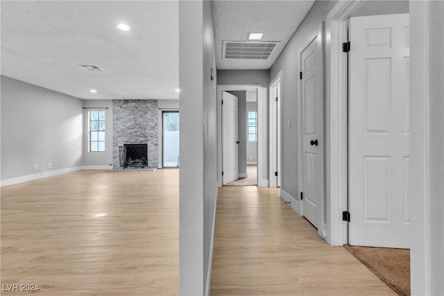 hallway featuring light hardwood / wood-style flooring and a textured ceiling