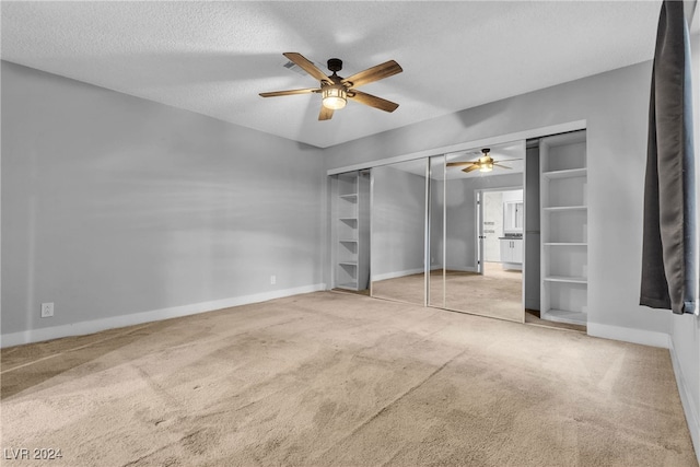 unfurnished bedroom with ceiling fan, a closet, carpet floors, and a textured ceiling