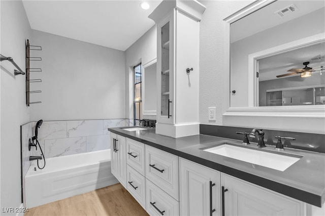 bathroom with a bathing tub, vanity, ceiling fan, and hardwood / wood-style floors