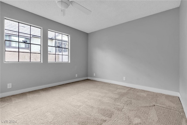 carpeted empty room featuring ceiling fan and a textured ceiling