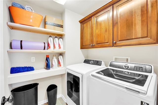 clothes washing area featuring independent washer and dryer, tile patterned floors, and cabinets