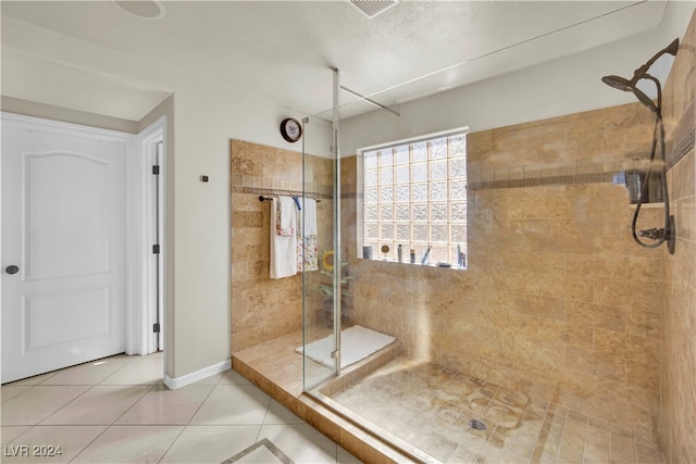 bathroom featuring tile patterned flooring and a tile shower