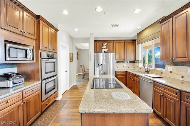 kitchen featuring light hardwood / wood-style floors, a center island, sink, and stainless steel appliances