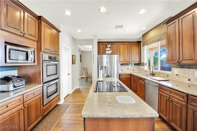 127 Birch Ridge Ave, Las Vegas, NV 89183 - kitchen featuring appliances with stainless steel finishes, a center island, decorative backsplash, light stone counters, and recessed lighting