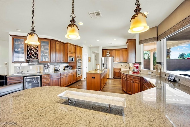 127 Birch Ridge Ave, Las Vegas, NV 89183 - kitchen featuring wine cooler, appliances with stainless steel finishes, light stone countertops, brown cabinetry, and recessed lighting