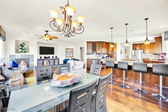 127 Birch Ridge Ave, Las Vegas, NV 89183 - dining room featuring a ceiling fan, a fireplace, recessed lighting, wood finished floors, and a chandelier