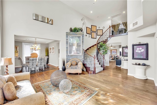 living room with a notable chandelier, a high ceiling, and hardwood / wood-style floors