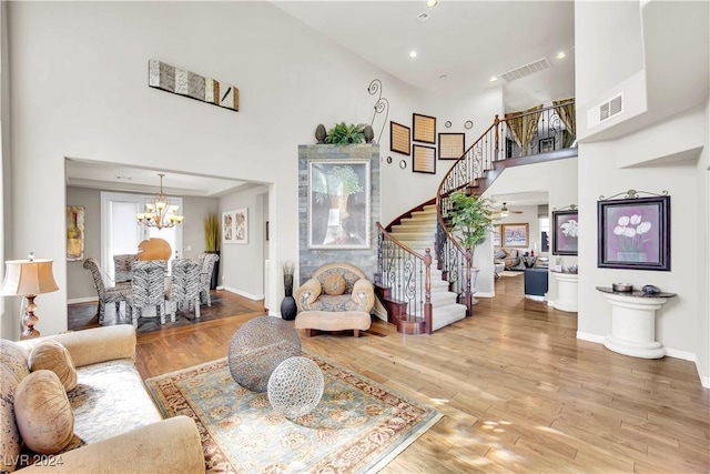 127 Birch Ridge Ave, Las Vegas, NV 89183 - living area featuring stairs, a chandelier, a towering ceiling, wood finished floors, and recessed lighting