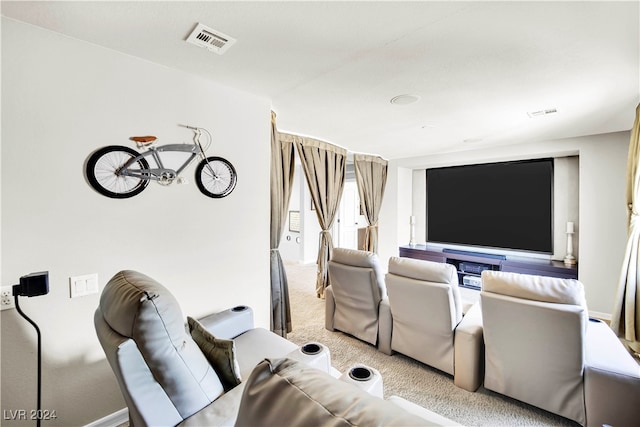 home theater room featuring light colored carpet