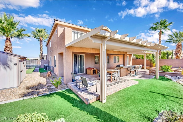 back of house with a pergola, a patio, and a lawn