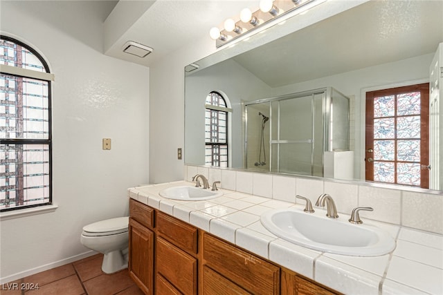 bathroom featuring tile patterned flooring, vanity, toilet, and a shower with shower door