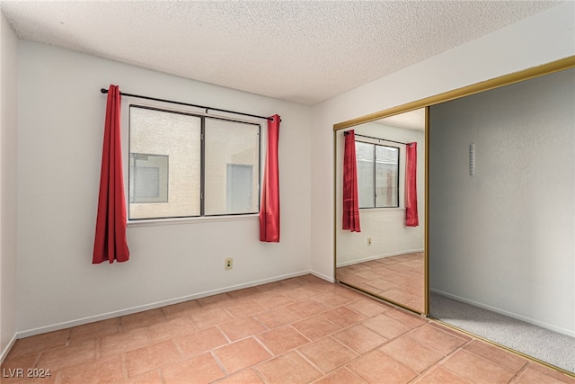 tiled empty room with a textured ceiling