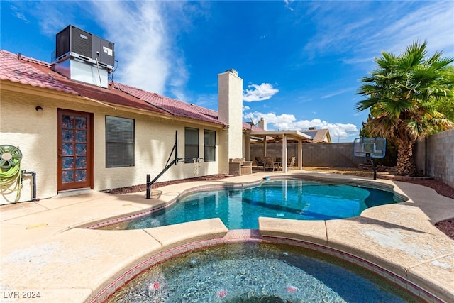 view of swimming pool featuring an in ground hot tub, central AC unit, and a patio area