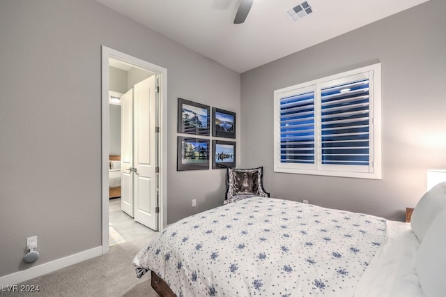 bedroom featuring connected bathroom, ceiling fan, and light colored carpet