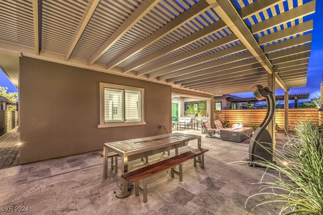 patio at night with outdoor lounge area and a pergola