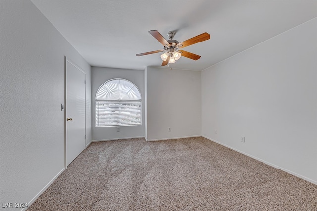 carpeted spare room featuring ceiling fan