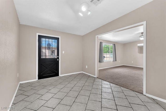 entrance foyer with ceiling fan and light colored carpet