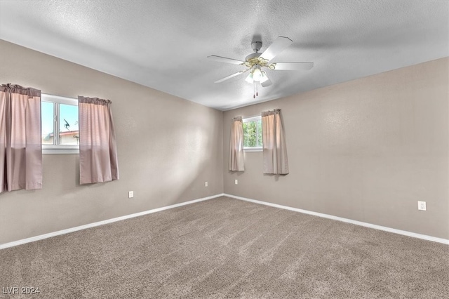 unfurnished room with ceiling fan, a textured ceiling, and carpet