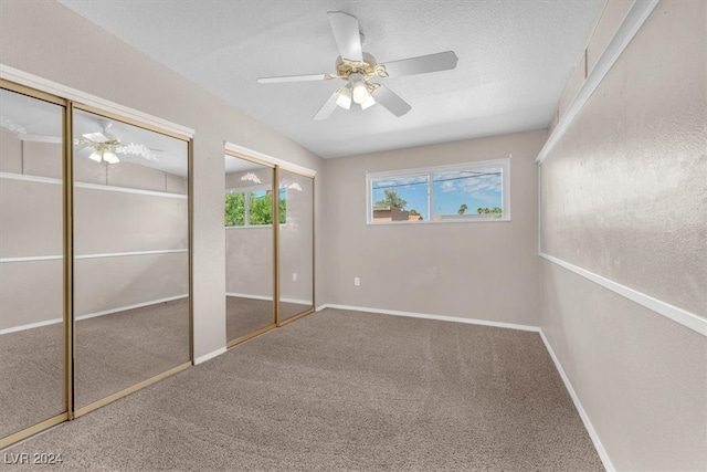 unfurnished bedroom with carpet flooring, two closets, and ceiling fan