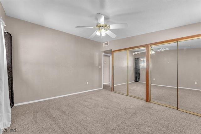 unfurnished bedroom with carpet flooring, ceiling fan, and multiple closets