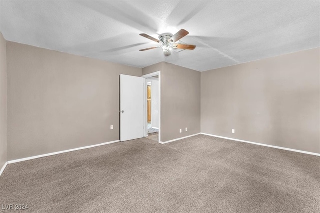 carpeted spare room with ceiling fan and a textured ceiling