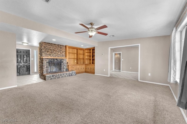 unfurnished living room featuring ceiling fan, a textured ceiling, a fireplace, and carpet