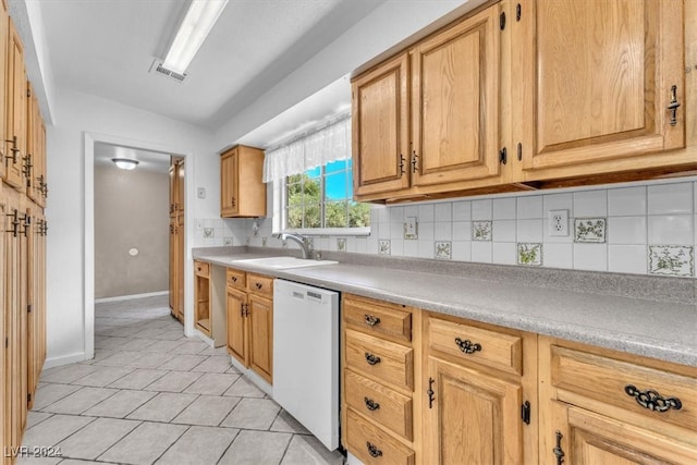 kitchen with light tile patterned flooring, dishwasher, sink, and decorative backsplash