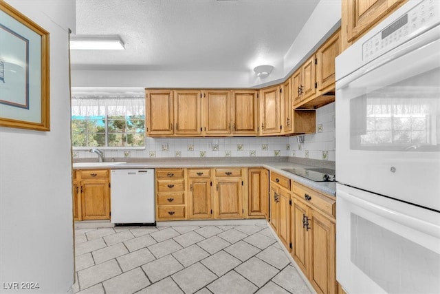 kitchen with white appliances, tasteful backsplash, and sink