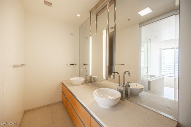 bathroom with tile patterned floors, independent shower and bath, and vanity