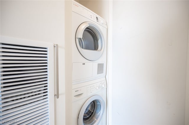 laundry area featuring stacked washer / drying machine