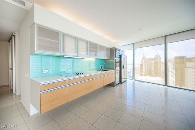 3726 Las Vegas Blvd Unit 2604, Las Vegas, NV 89158 - kitchen with black electric cooktop, light countertops, light tile patterned floors, glass insert cabinets, and modern cabinets