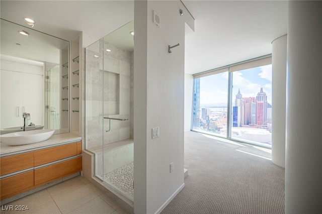 bathroom featuring a shower with shower door and vanity